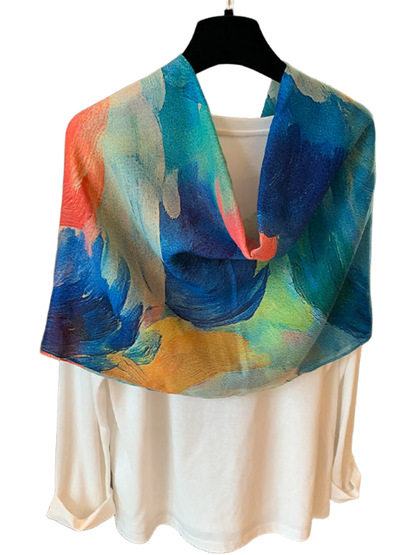 Blue scarf looped over a white top, showing blue, teal and yellow painterly sections