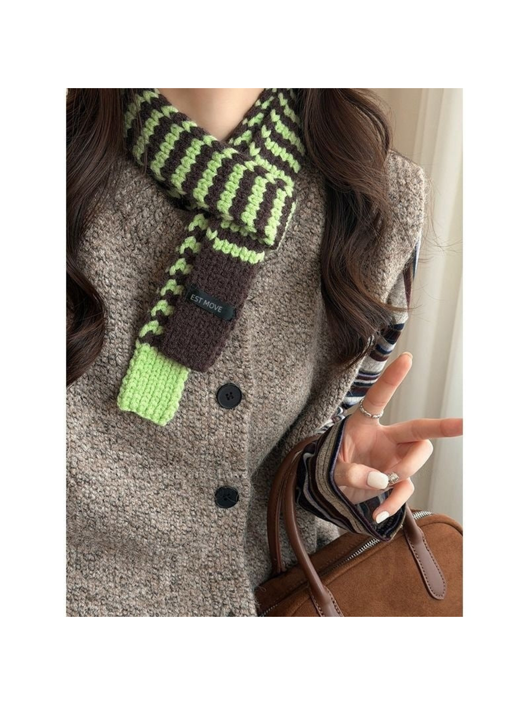 Green striped knit scarf with dark brown and green end panels, knotted at the neck