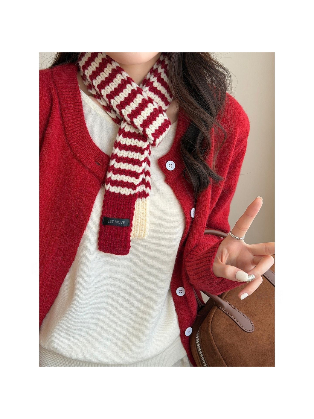 Red striped knit scarf with contrasting end panels, knotted over a white top