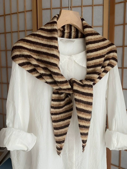 Beige striped scarf tied over a white shirt