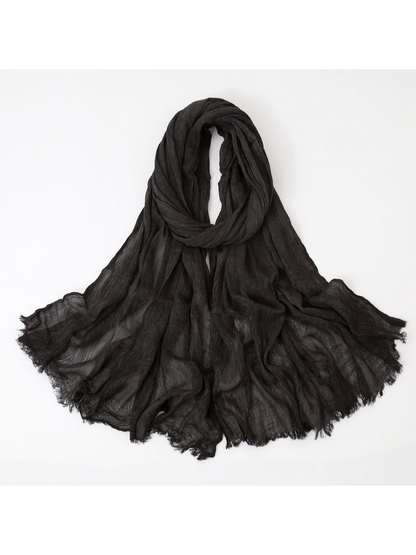 Black scarf looped with crinkled texture and fringed edges