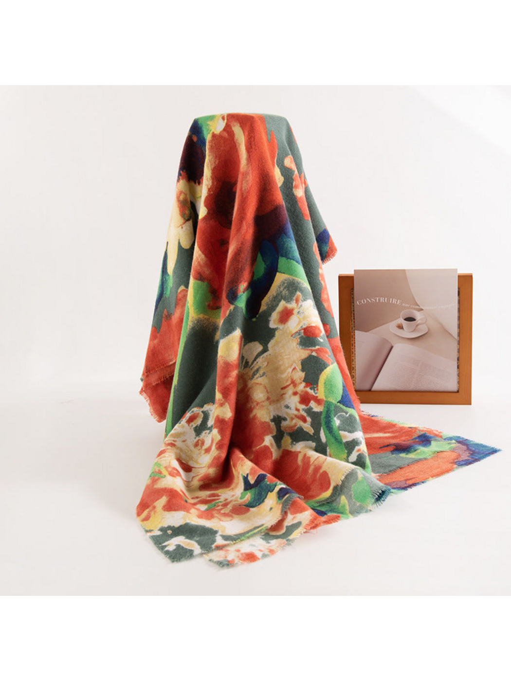 Floral scarf draped upright with its length spread across a white surface