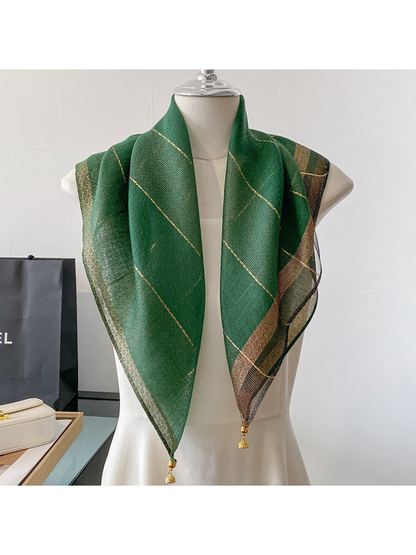 Green scarf draped on a mannequin with metallic-look lines and gold-tone end ornaments