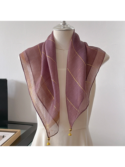 Purple scarf draped on a mannequin with metallic-look lines and gold-tone end ornaments