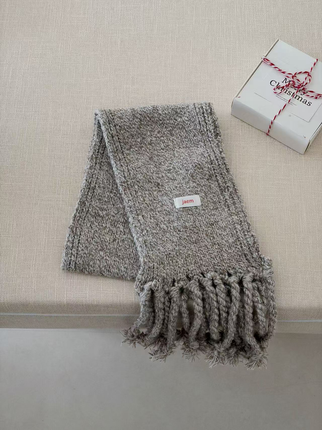 Gray marled knit scarf folded with thick twisted fringe