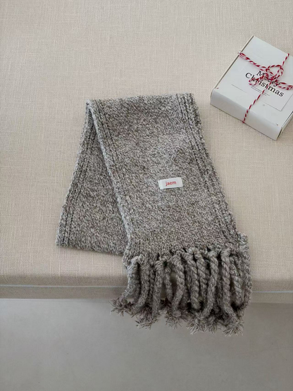 Gray marled knit scarf folded with thick twisted fringe