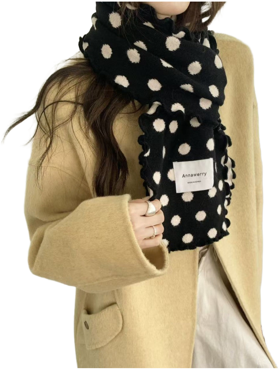 Black polka dot scarf wrapped around the neck, showing ruffled edges and knit texture
