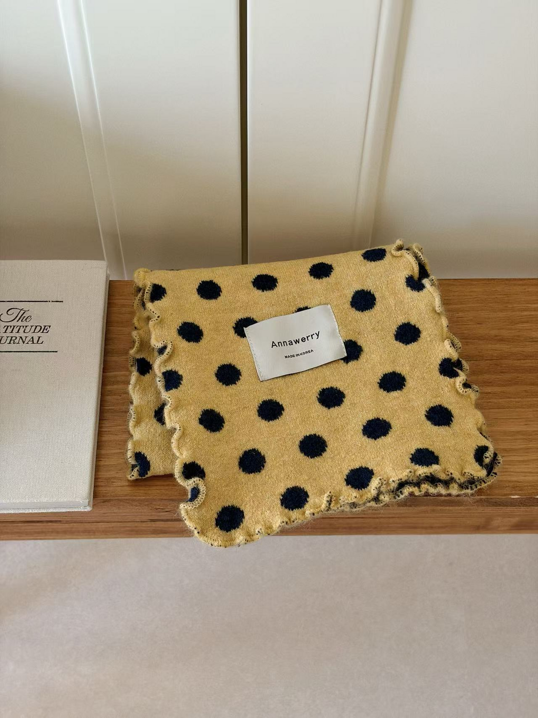 Yellow polka dot scarf folded to show its ruffled edges