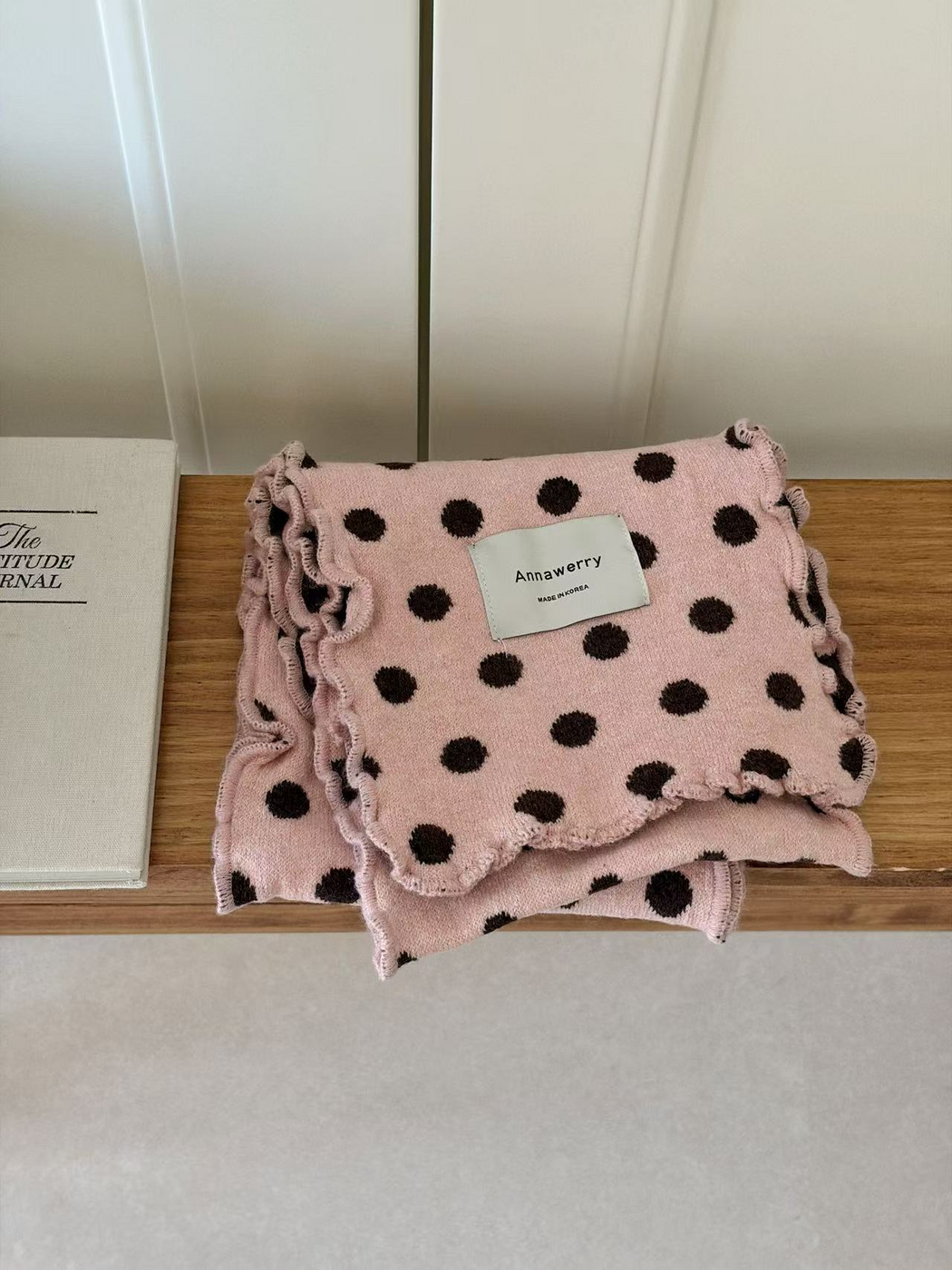 Pink polka dot scarf folded to show its ruffled edges
