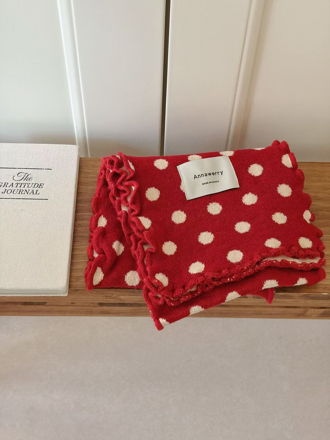 Red scarf with ivory polka dots and ruffled edges, folded view