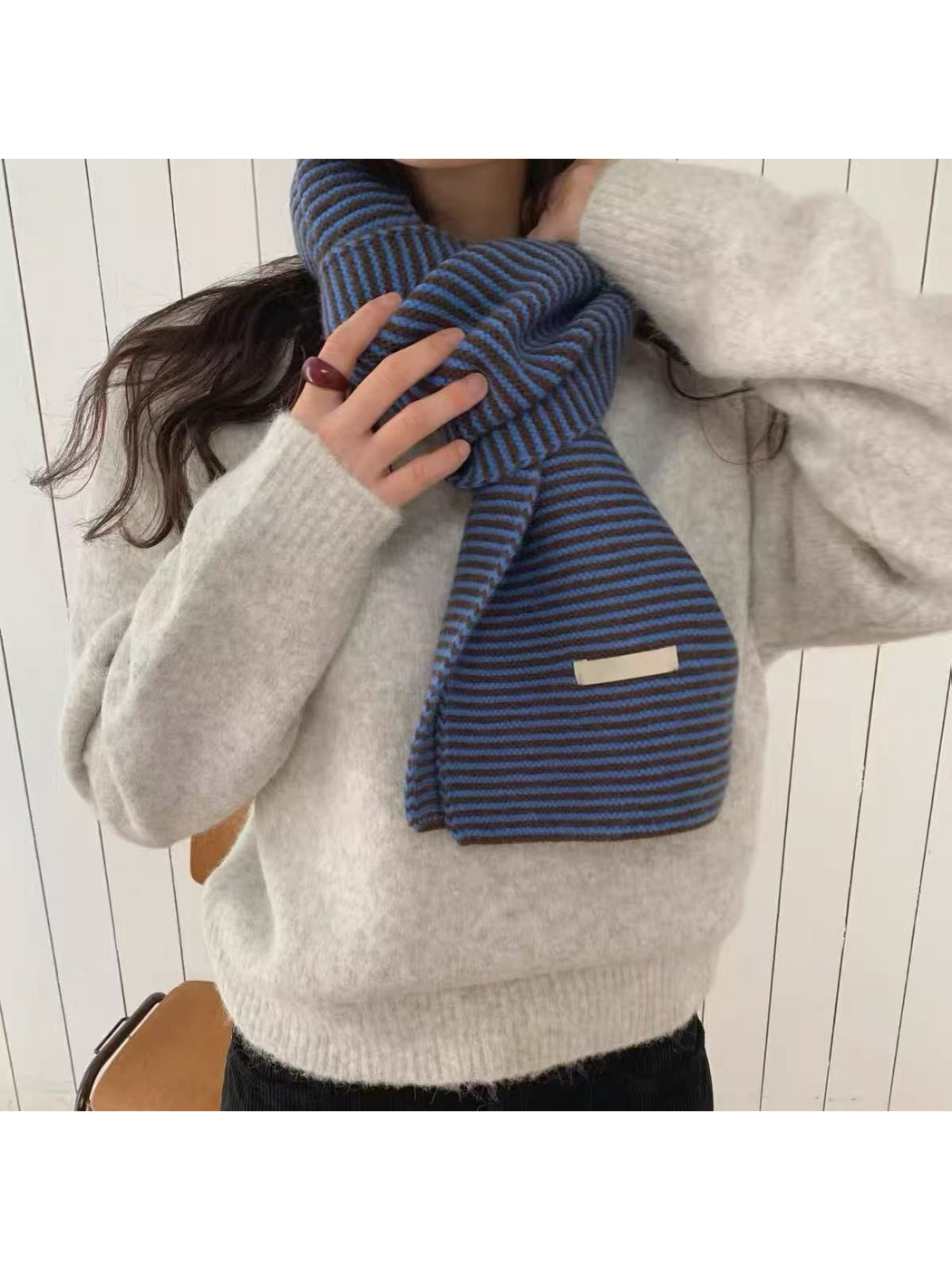 Blue striped knit scarf wrapped around the neck, close-up