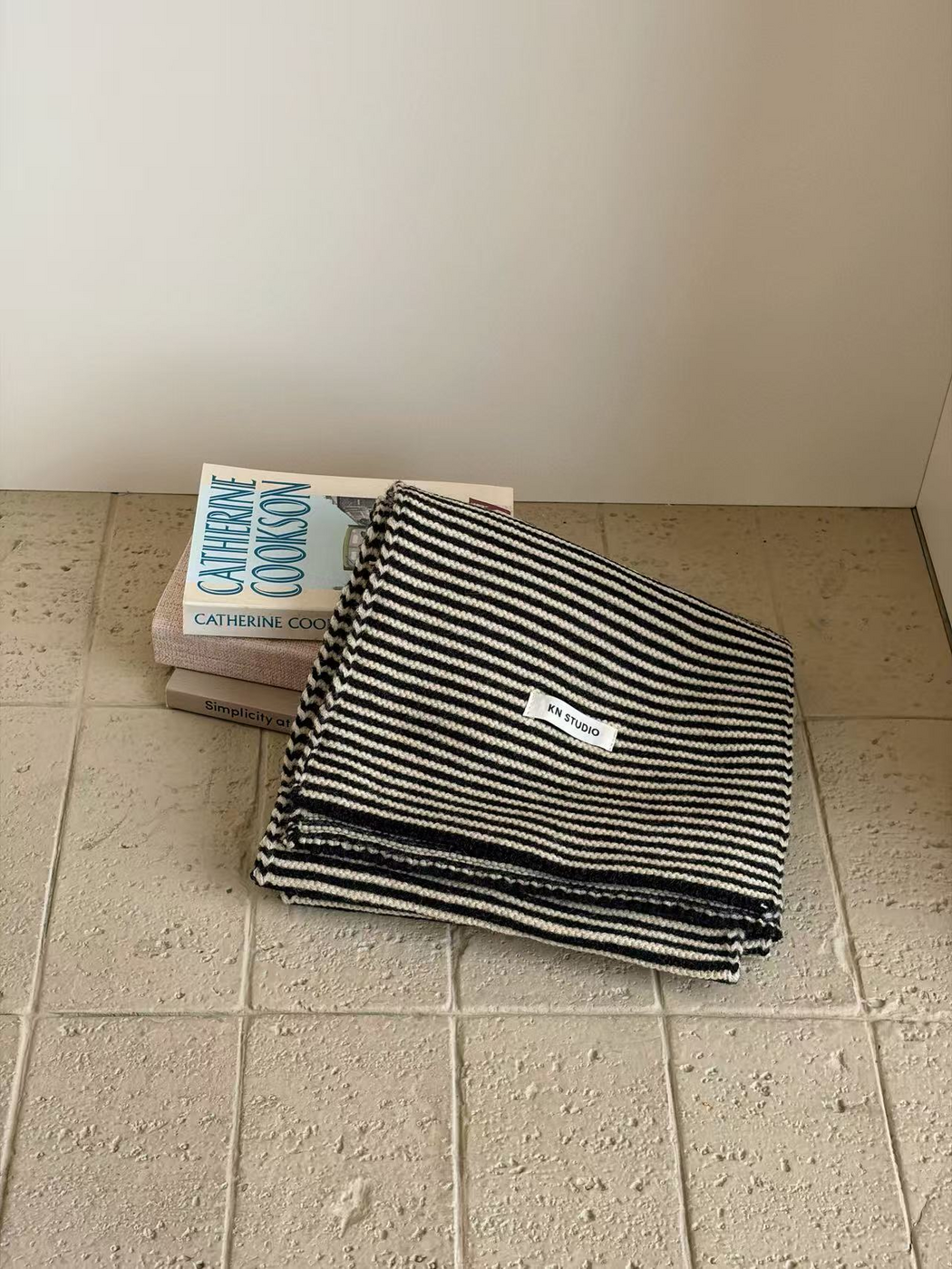 Black striped knit scarf folded with its KN STUDIO label visible