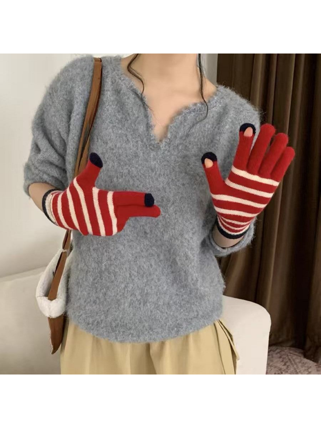 Red striped gloves worn with palms facing forward