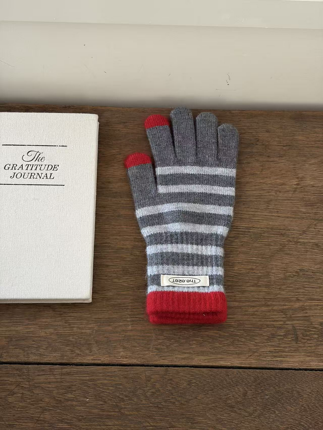Gray striped glove with red cuff and contrasting thumb and index fingertips