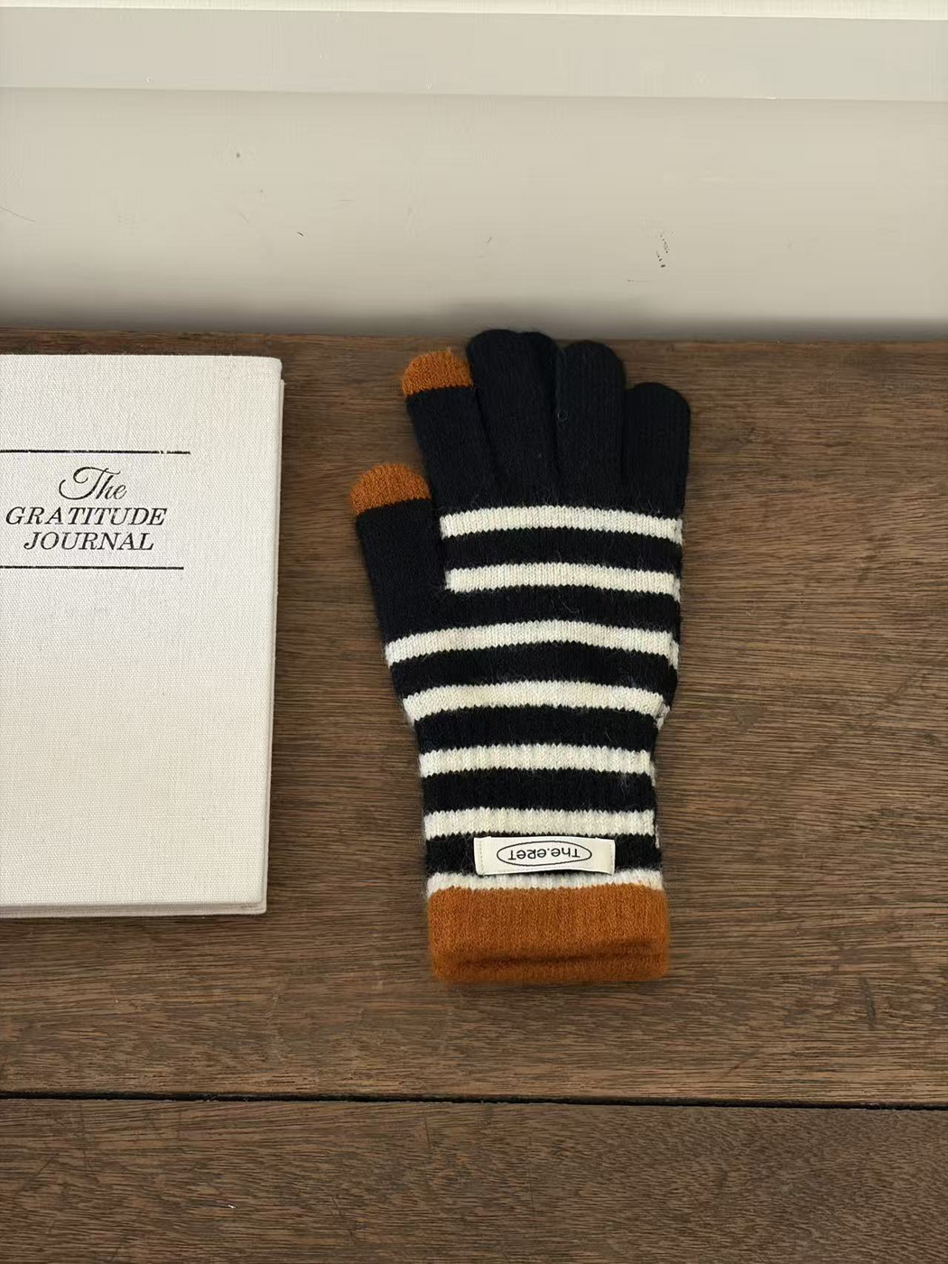 Black glove with ivory stripes, ochre cuff and contrasting fingertips