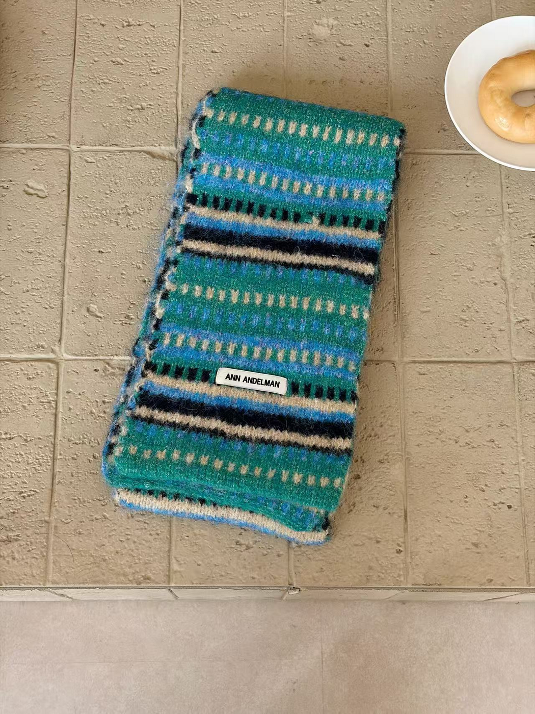 Blue scarf folded lengthwise, with turquoise, blue, navy and cream stripes and dash rows