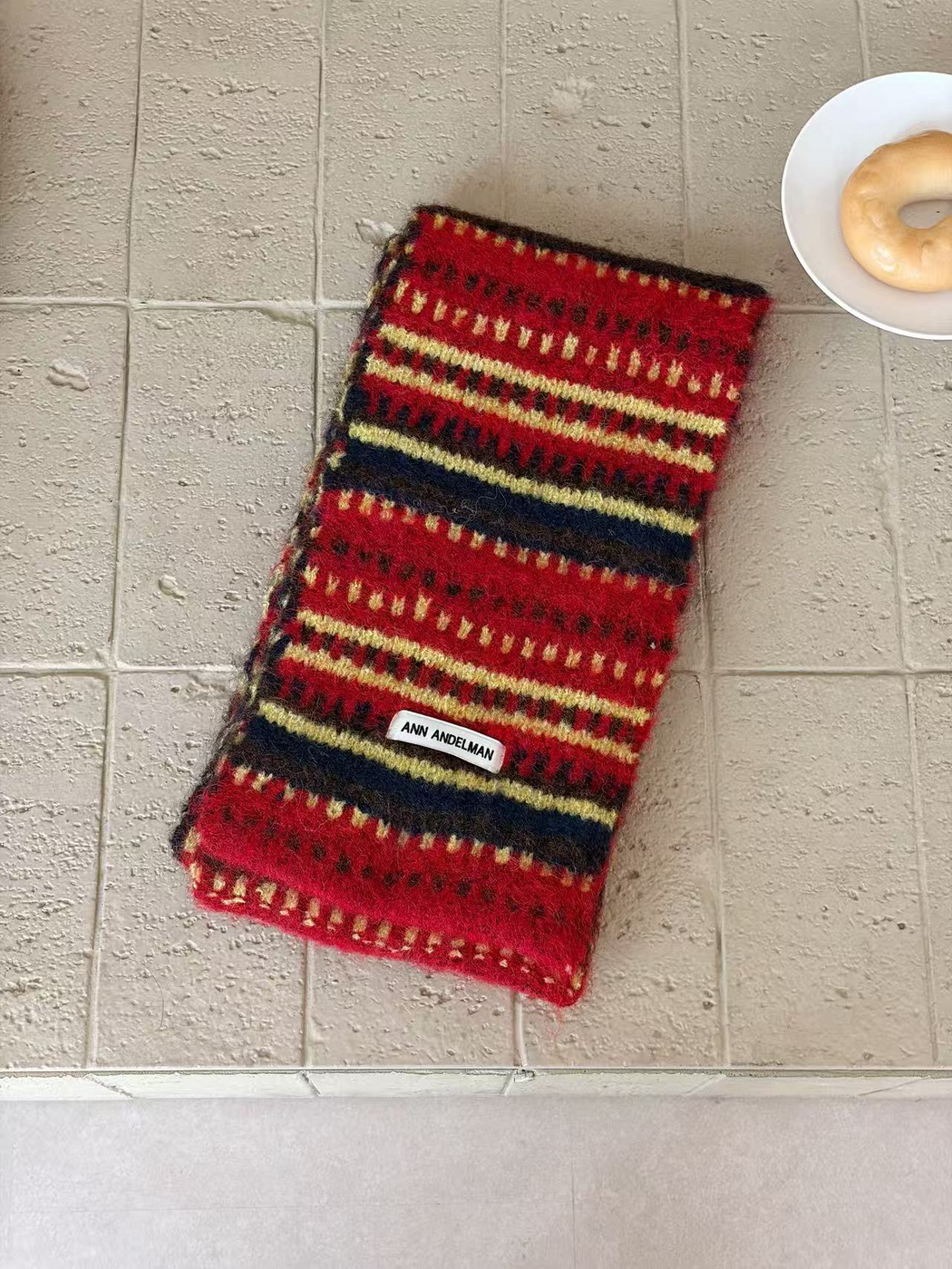 Burgundy scarf folded lengthwise, with pale yellow dash rows and broad navy stripes