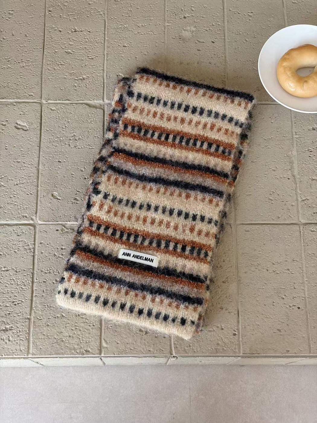 Khaki scarf folded lengthwise, with rust dash rows and bands and navy stripes