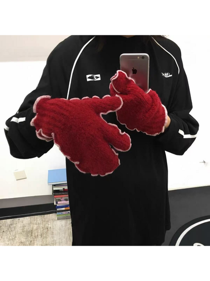 Red mittens with pale ruffled edging worn with a black top