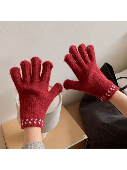 Gloves worn with fingers spread, showing contrasting cuff embroidery
