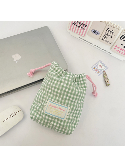 Green gingham drawstring pouch with curved quilting, pink drawcords and a rectangular front patch