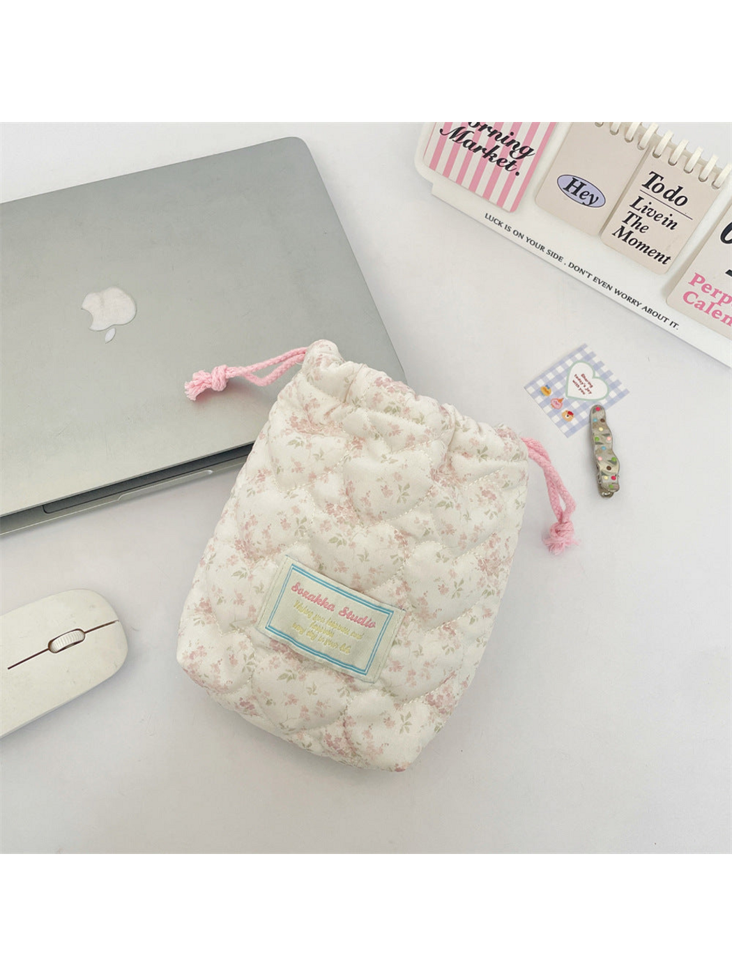 Pink floral drawstring pouch with curved quilting and pink drawcords, front view