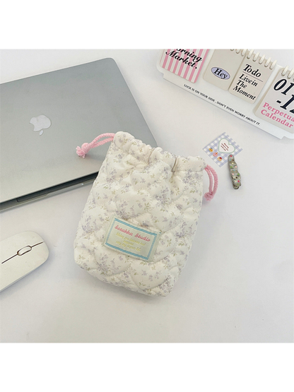 Purple floral drawstring pouch with curved quilting and pink drawcords, front view