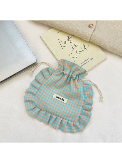 Turquoise drawstring pouch with orange checks and ruffled trim, flat view