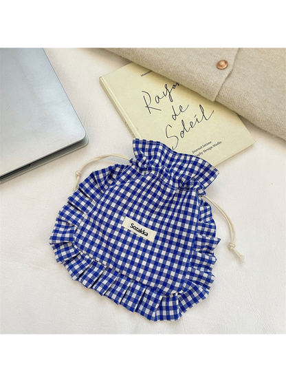 Blue gingham drawstring pouch with ruffled trim and cream knotted cords