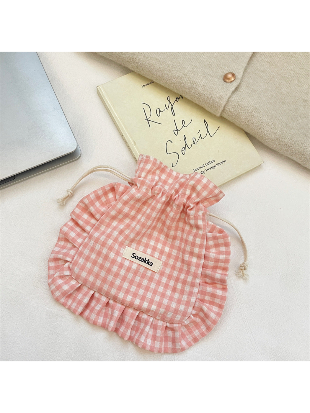 Pink gingham drawstring pouch with cream cords and ruffled border, front view