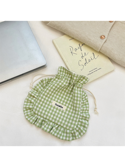 Green gingham drawstring pouch with cream cords and ruffled border, front view
