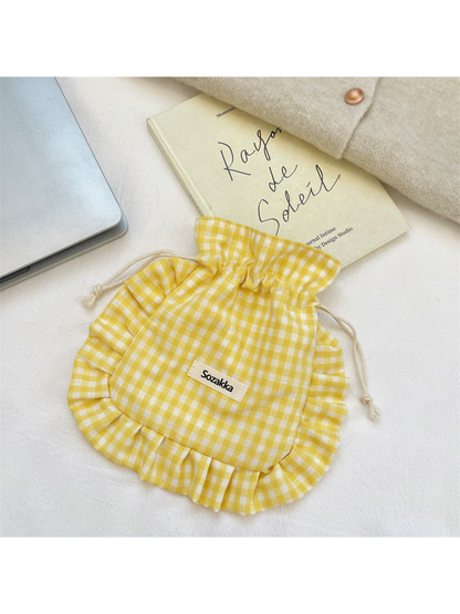 Yellow gingham drawstring pouch with knotted cream cords and ruffled border