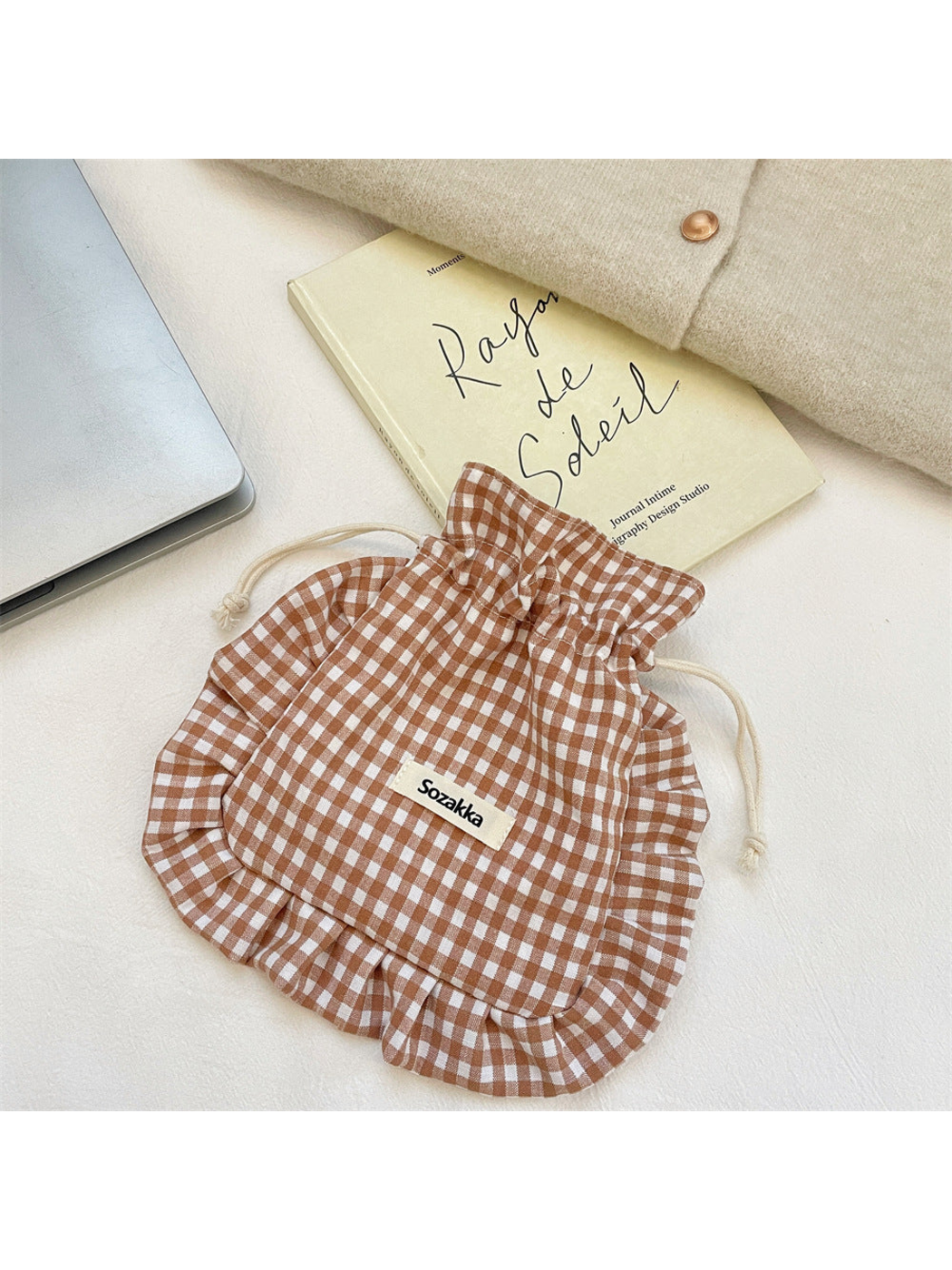 Brown gingham drawstring pouch with cream cords and ruffled border, front view