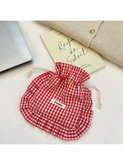 Red gingham drawstring pouch with cream cords and ruffled border, front view