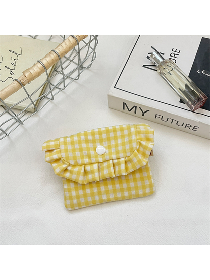 Yellow gingham coin purse with a ruffled flap and white snap, front view