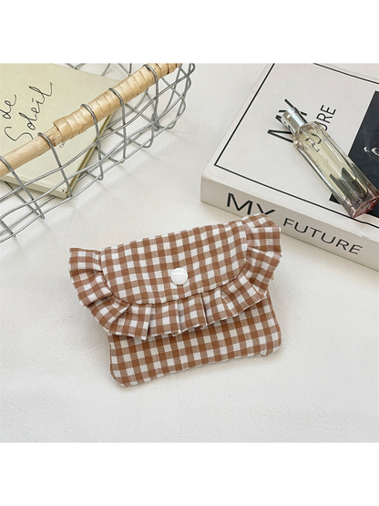 Brown gingham coin purse with a ruffled flap and white snap, front view