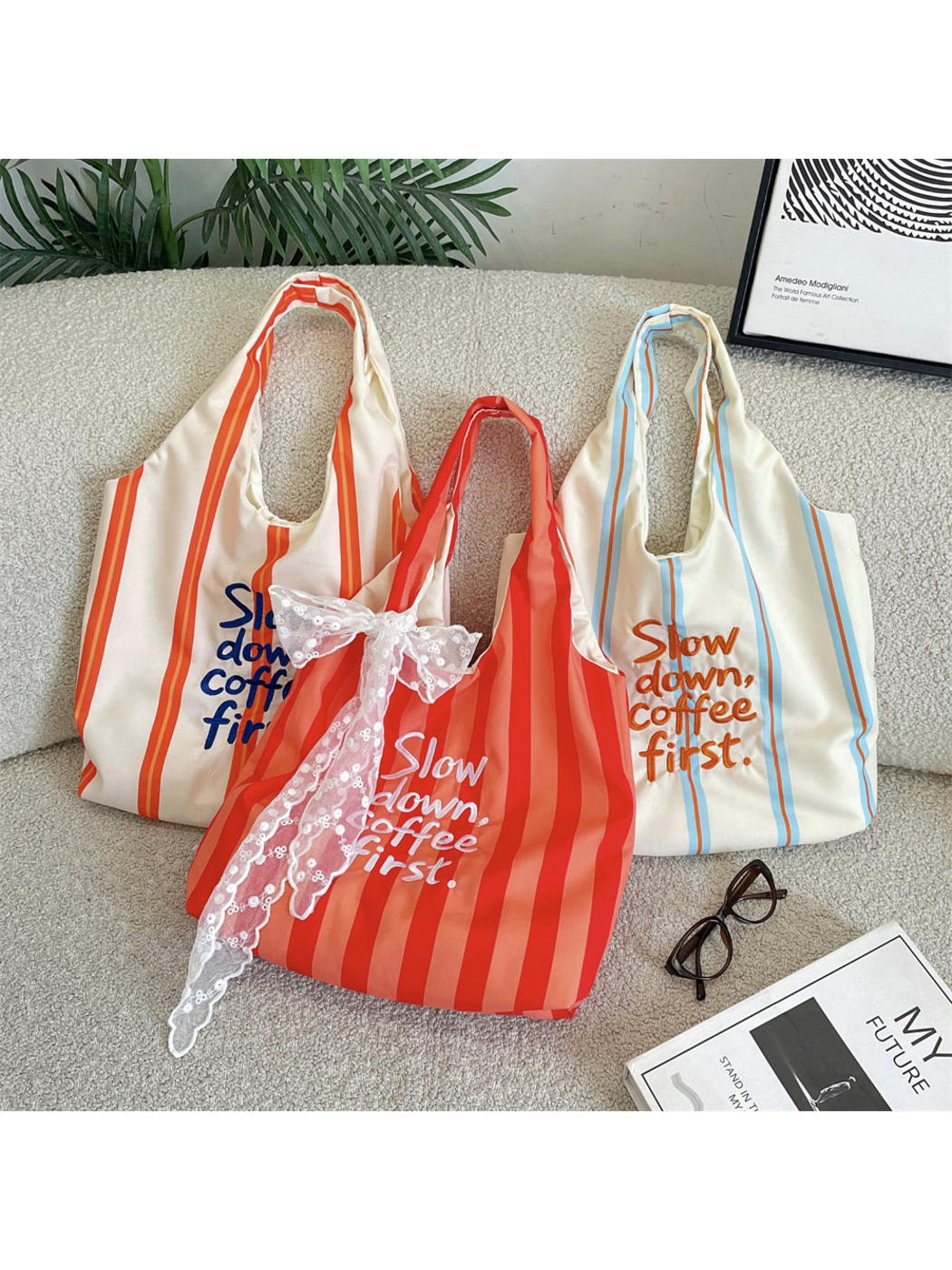 Red, Orange and Blue striped tote bag styles displayed together on a sofa