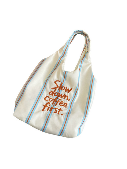 Blue tote bag with light blue and orange stripes and slogan lettering, front view