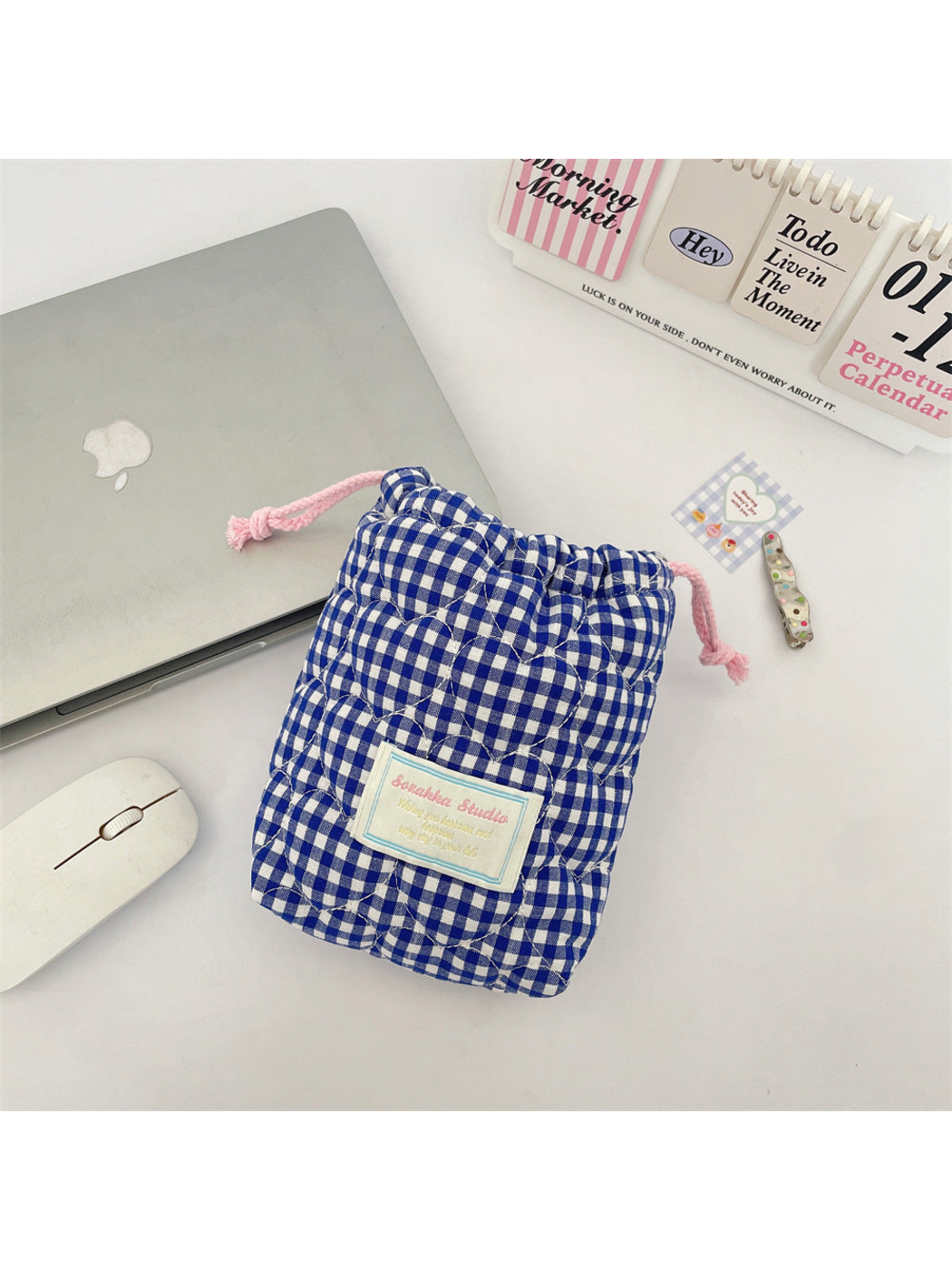 Blue gingham drawstring pouch with heart-shaped quilting, pink drawstrings and a rectangular front label