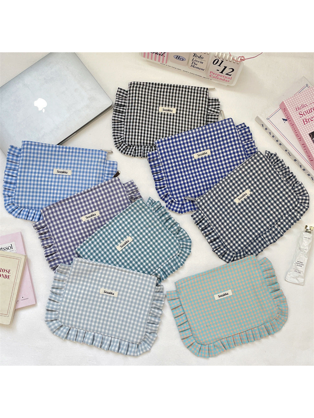 Gingham makeup pouches arranged together, showing checked patterns and ruffled edging