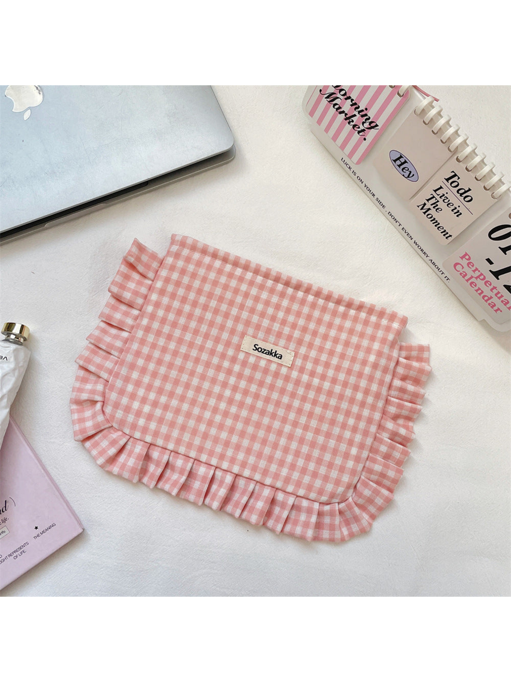 Pink gingham makeup pouch with ruffled edging, flat view