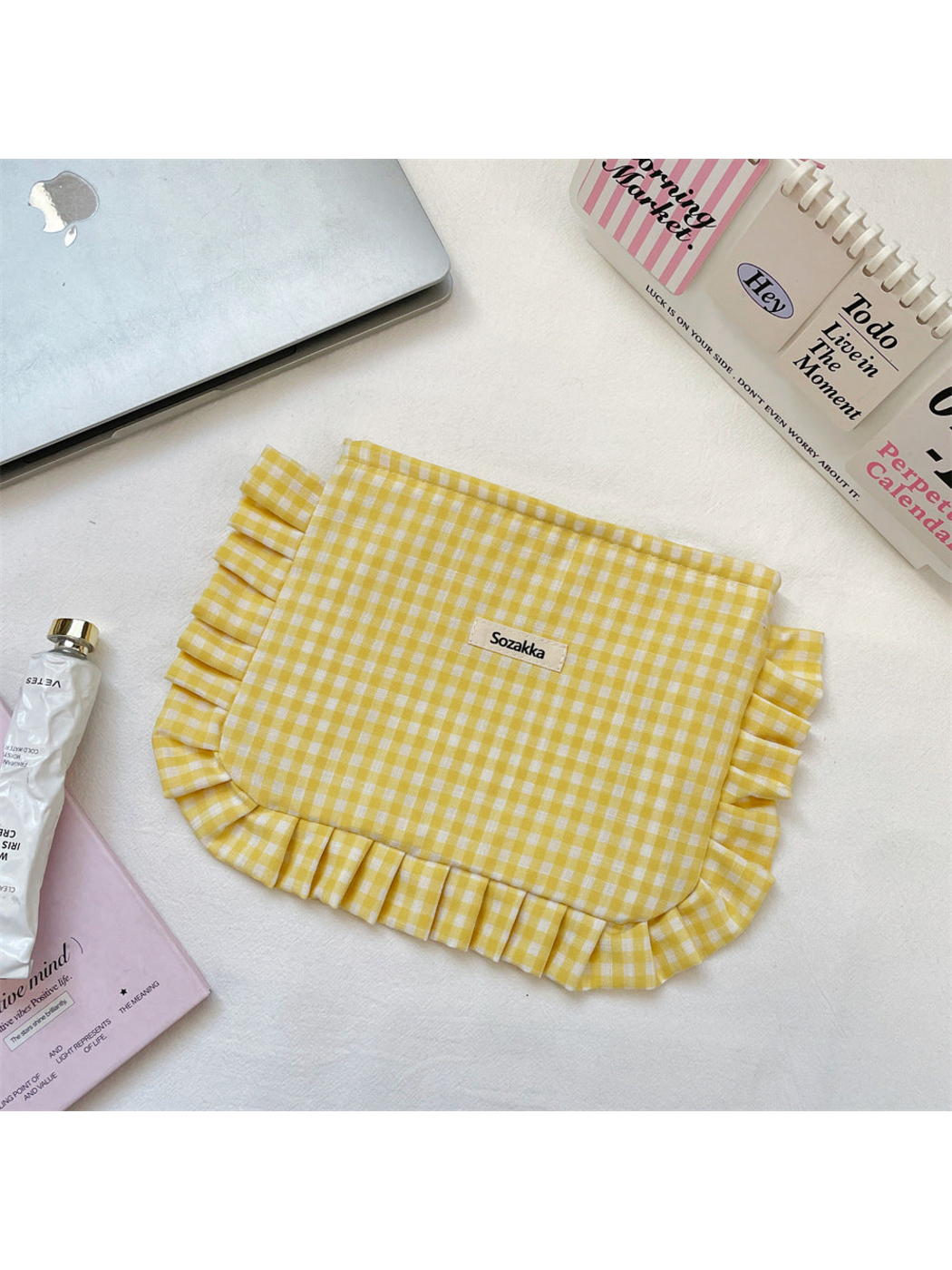Yellow gingham makeup pouch with ruffled edging, flat view