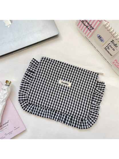 Black gingham makeup pouch with ruffled edging, flat view