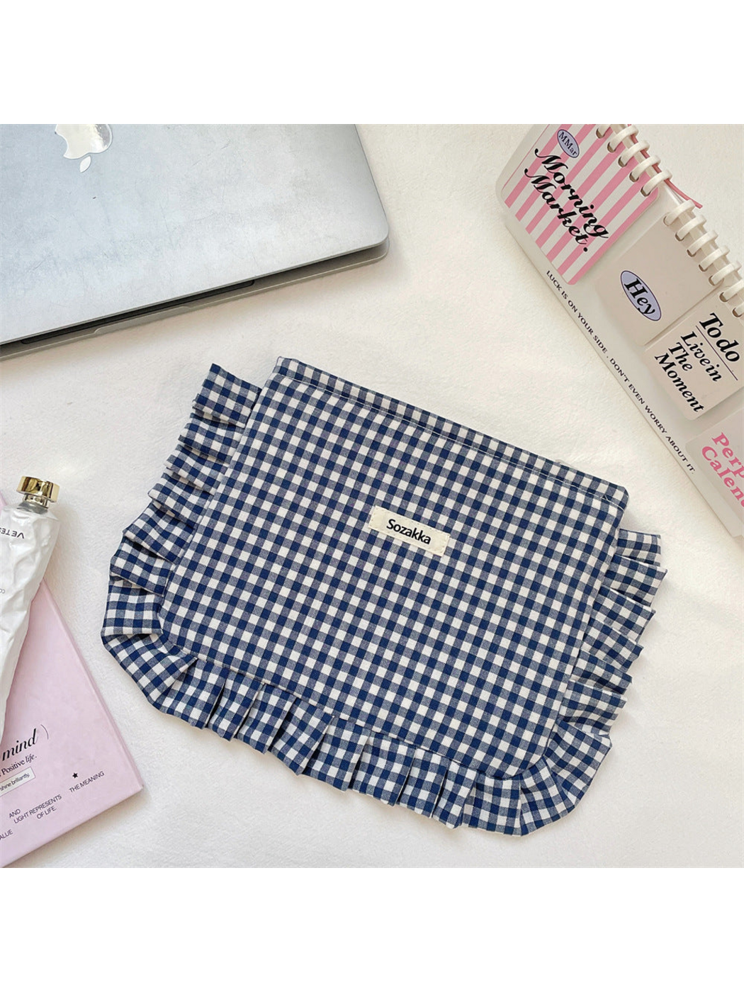 Navy gingham cosmetic pouch with white checks and ruffled trim, flat front view
