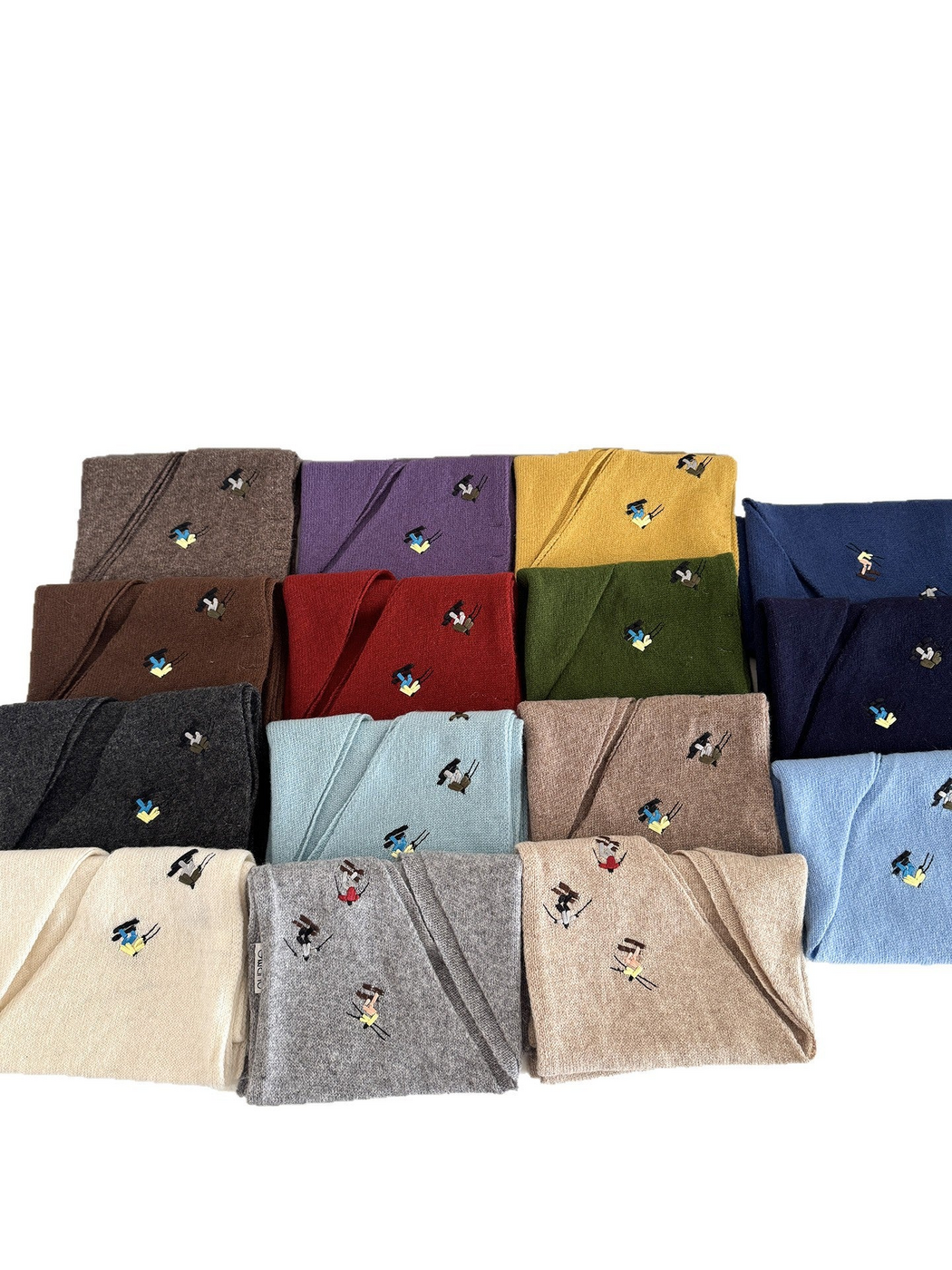 Folded knit scarves displaying embroidered winter-sport figures