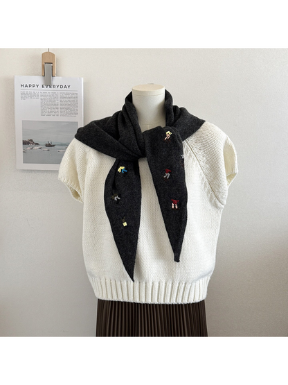 Black Gray knit triangle scarf with embroidered figures, tied on a mannequin
