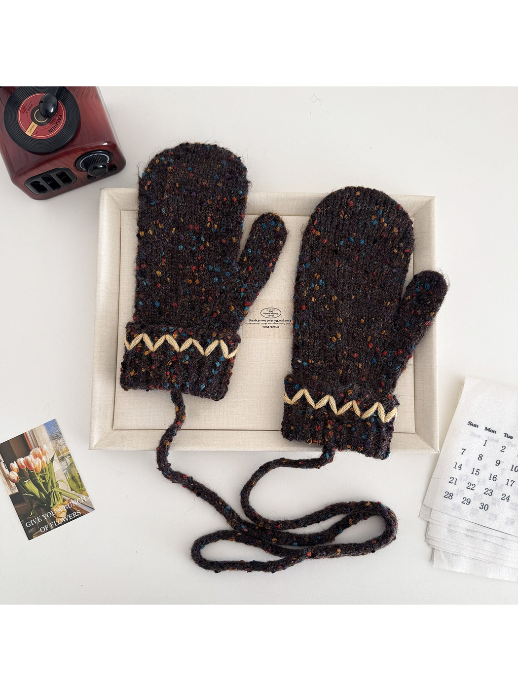 Coffee flecked mittens with cream zigzag cuffs and a connecting cord