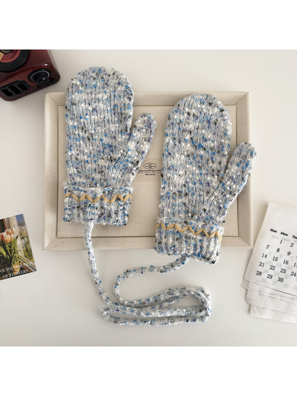 Beige flecked mittens with cream zigzag cuffs and a connecting cord