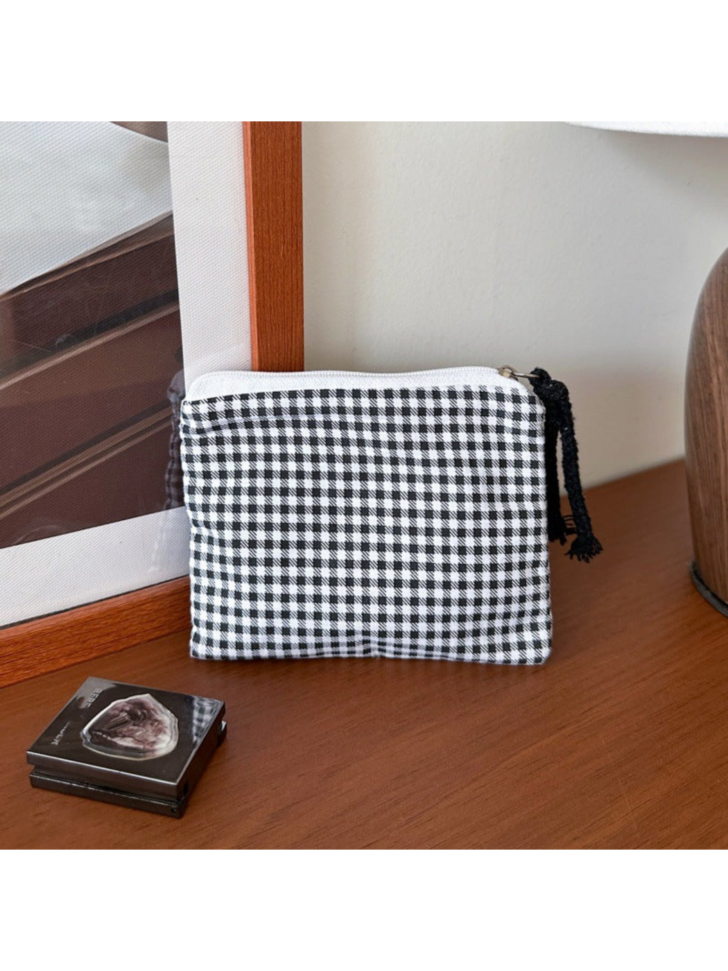 Black makeup bag with black-and-white gingham checks and a black cord pull