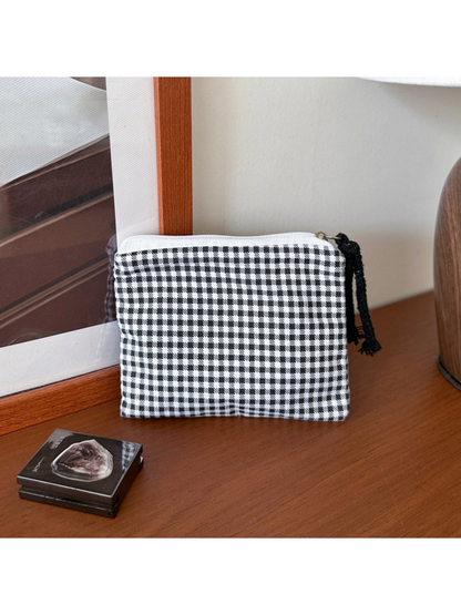 Black makeup bag with black-and-white gingham checks and a black cord pull